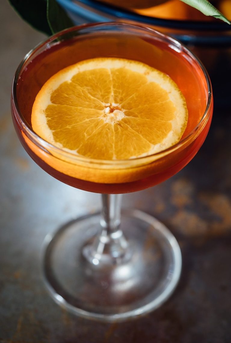 Selbstgemachter Orangenlikör im Glas mit frischen Früchten, Kräutern und Gewürzen – aromatischer DIY-Likör zum Genießen oder Verschenken