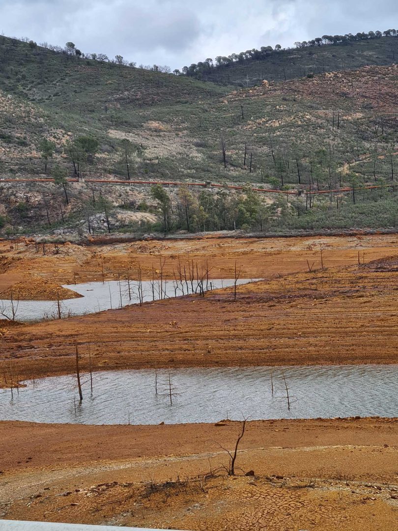 Unwirkliche, vom Menschen geprägte Landschaft am Río Tinto mit rötlich gefärbtem Wasser bei einer Wohnmobil-Rundreise Spanien