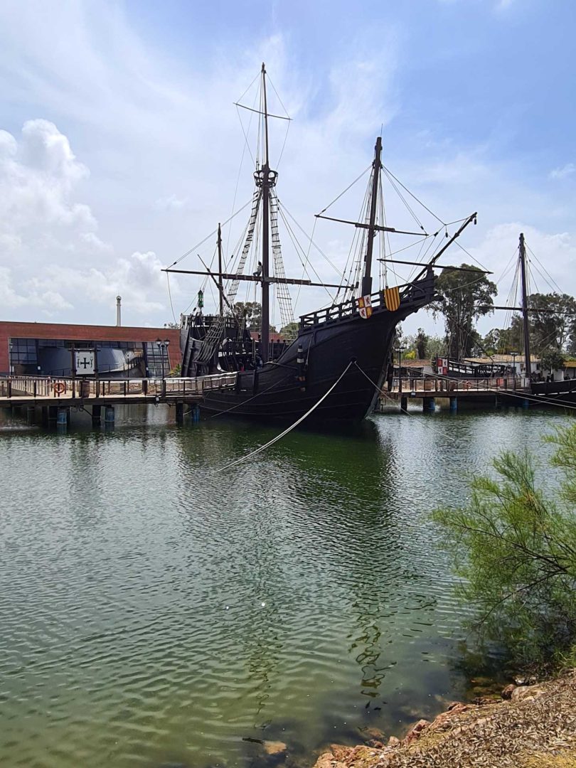 Kolumbus-Schiff liegt vor Anker im Hafen des Muelle de las Carabelas, umgeben von ruhigem Wasser – Wohnmobil-Rundreise Spanien