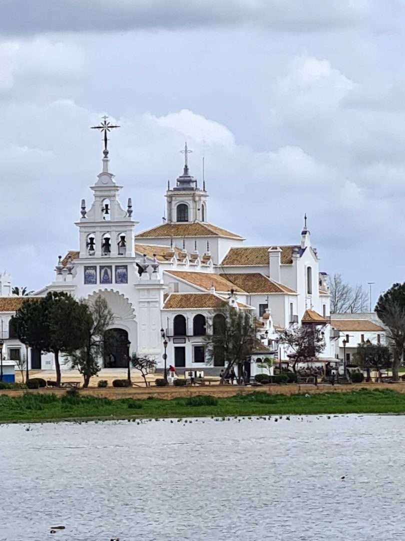 Wallfahrtskirche El Rocío mit ihrer markanten weißen Fassade in der staubigen Weite von El Rocío – Wohnmobil-Rundreise Spanien