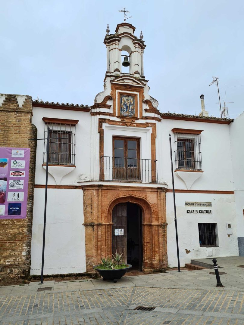 Blick auf das historische Hospital in Niebla mit auffälligem Glockenturm über dem Eingang – Wohnmobil-Rundreise Spanien