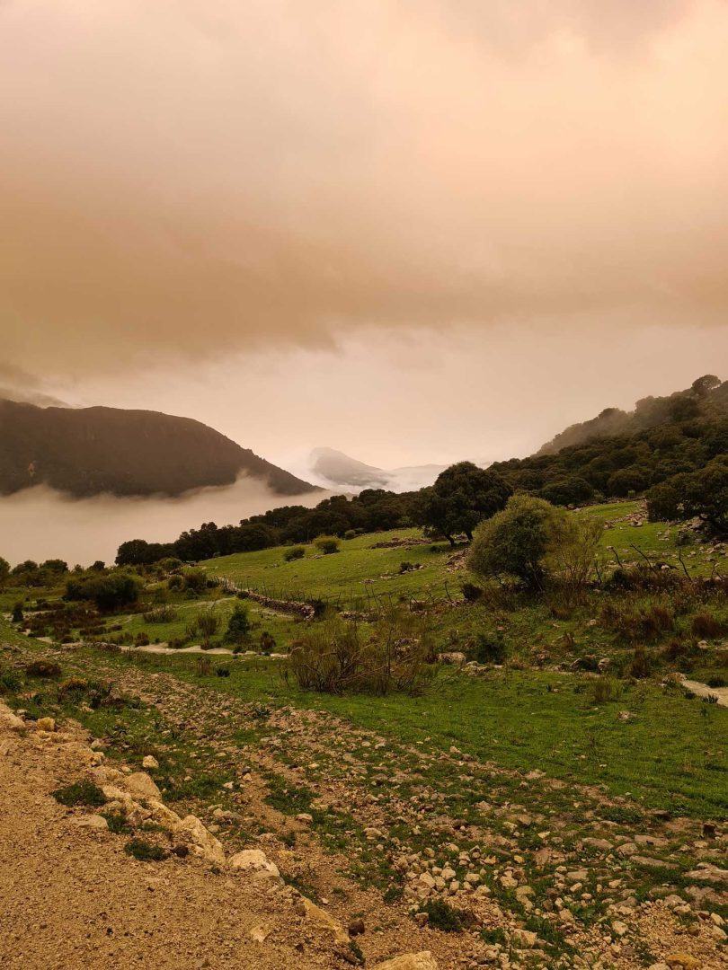 Straße vor uns, darüber dicke rote Wolken, darunter aufsteigender weißer Dunst – Wohnmobil-Rundreise Spanien