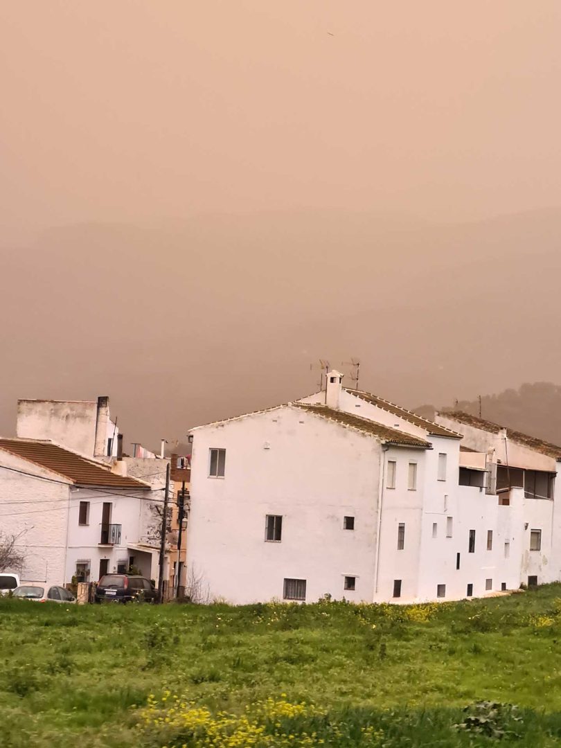 Einige Häuser unter einem Himmel mit dicken roten Wolken – Wohnmobil-Rundreise Spanien