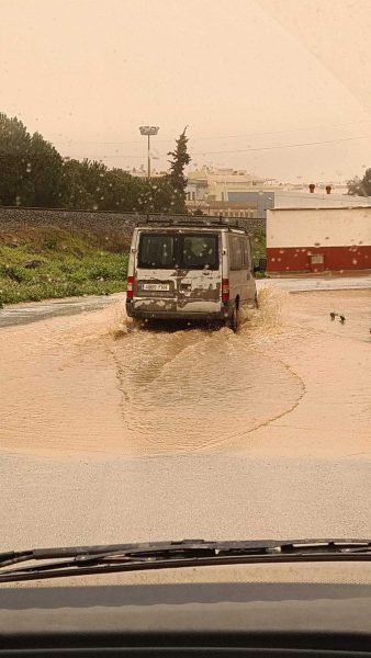 Ein Auto fährt vor uns durch etwa 30 cm hohes, schlammiges Wasser – eine echte Schlammdurchfahrt nach dem Regen – Wohnmobil-Rundreise Spanien