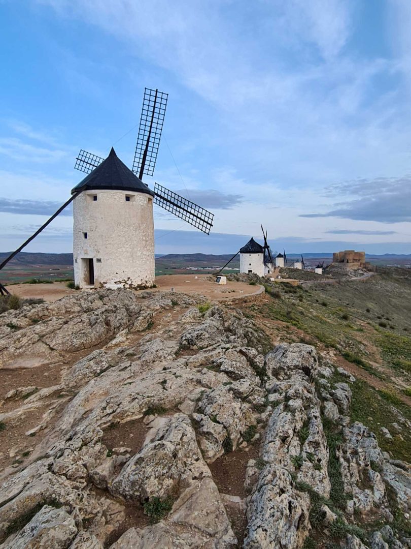Sechs Windmühlen stehen auf dem Hügel, dahinter thront das Kastell von Consuegra – Wohnmobil-Rundreise Spanien