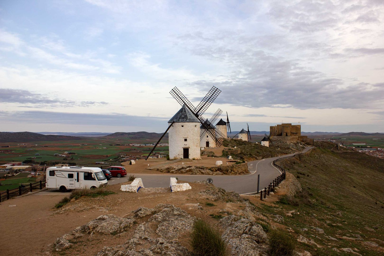 Fünf Windmühlen mit dem Kastell von Consuegra im Hintergrund, davor steht unser Wohnmobil – Wohnmobil-Rundreise Spanien