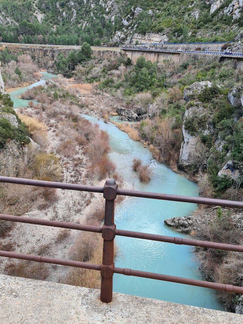 Wohnmobil fährt über eine Brücke über einen türkisfarbenen Fluss – Wohnmobil-Rundreise Spanien