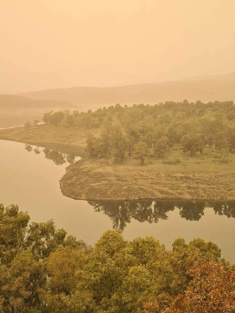 Blick von der Burgmauer in Ciudad Rodrigo auf den angrenzenden See und die orange gefärbte Landschaft bei Blutnebel – Wohnmobil-Rundreise Spanien